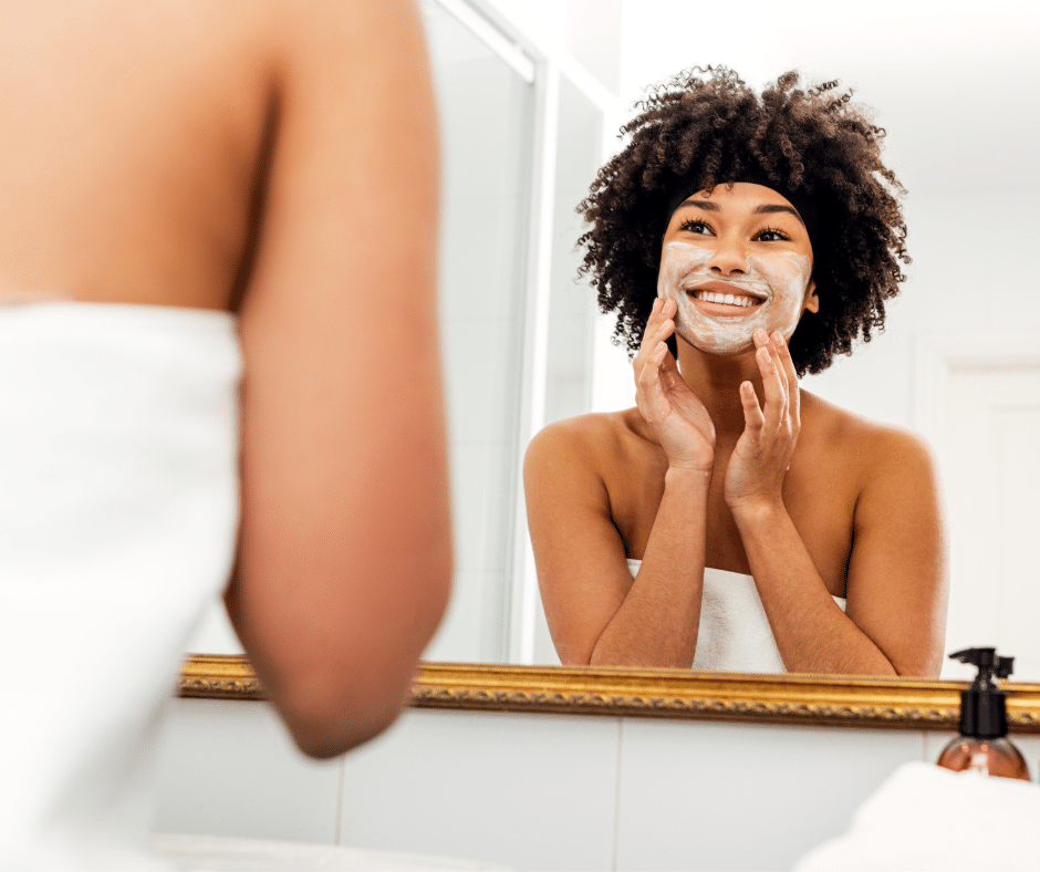 woman cleaning her face whilst looking in the mirror